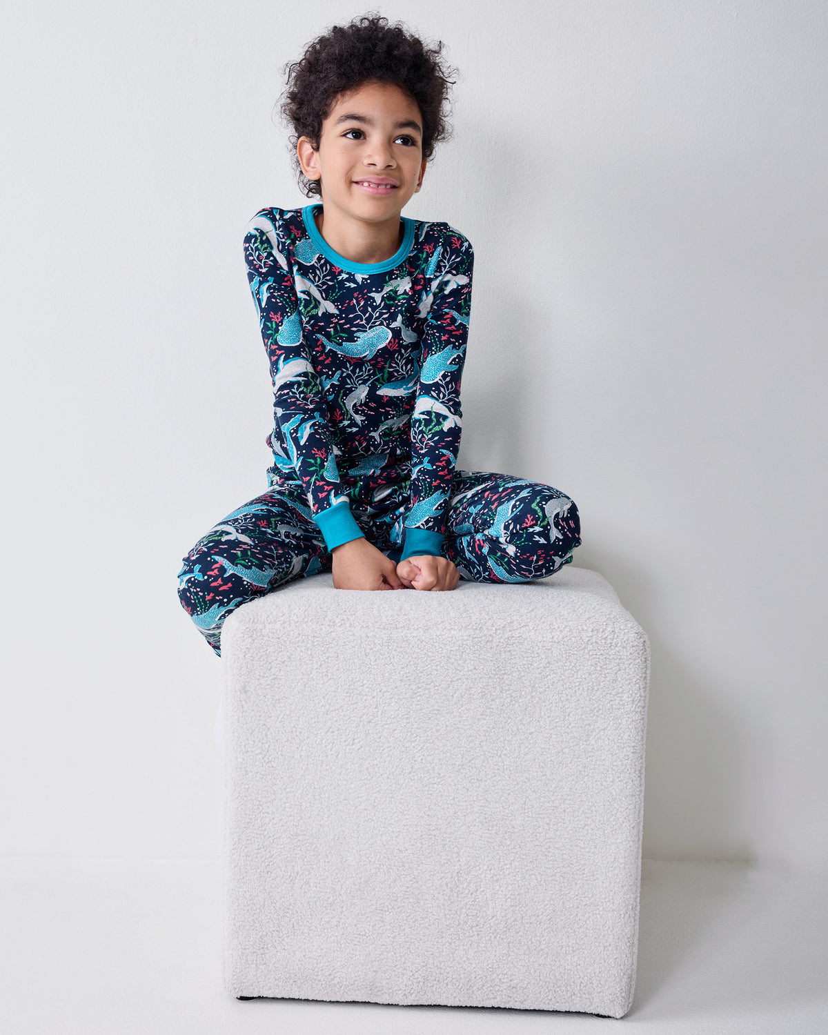 Child wearing the Blue Chill Arctic Sea Life kids pajama set with a long-sleeve top and matching pants.
