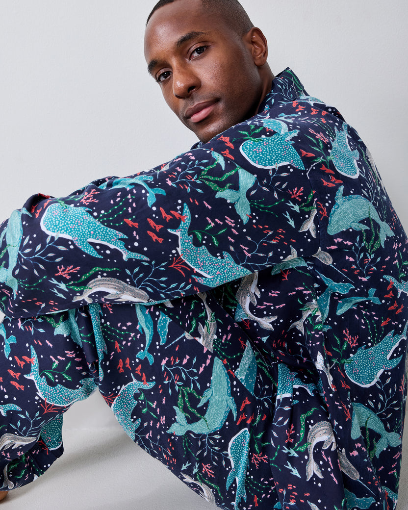 Close-up of a model wearing the Blue Chill Arctic Sea Life pajama set with a navy shirt covered in colorful aquatic and sea-life prints.
