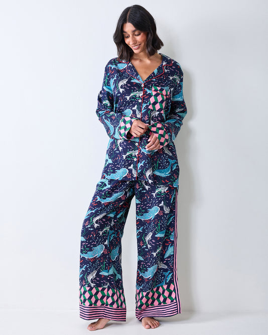 Full-length view of a person wearing a button-front Arctic Sealife pajama top and wide-leg pants with contrasting geometric cuffs and hems.