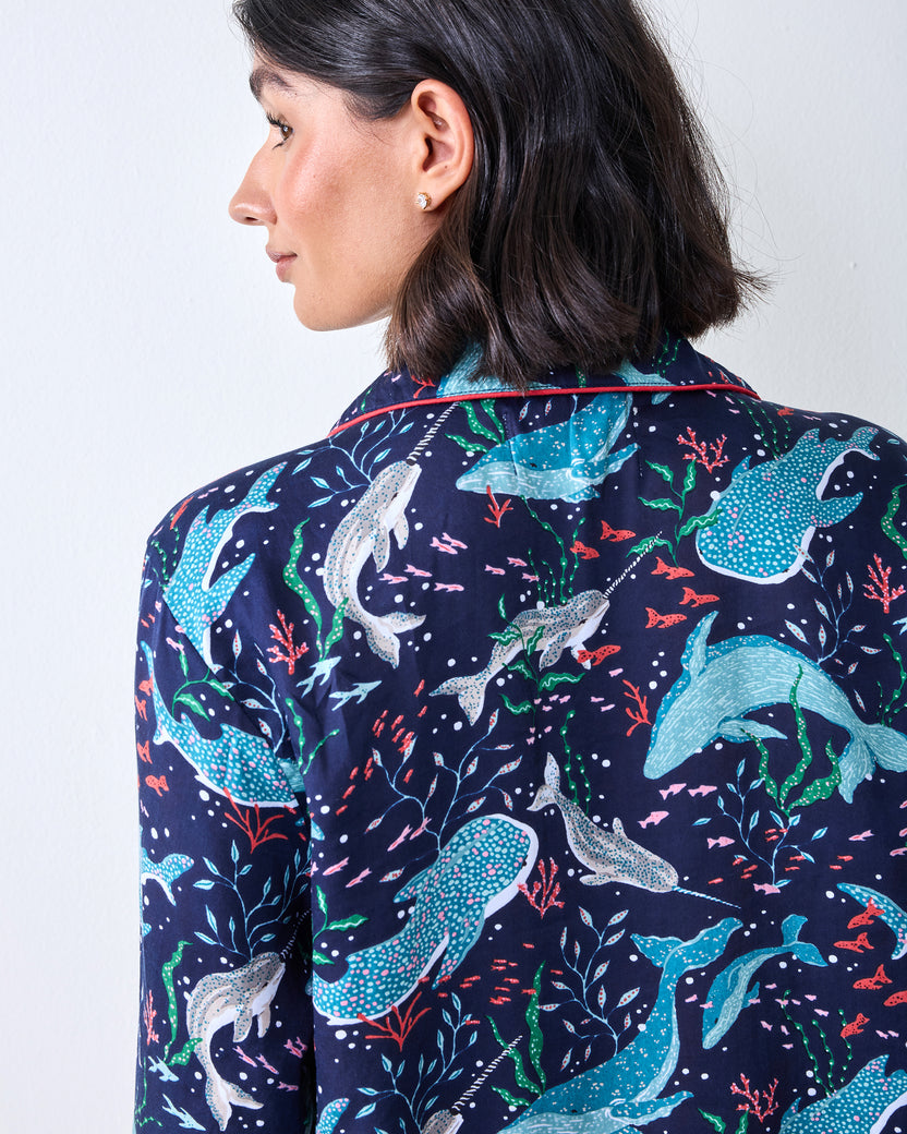 Close-up of the back of a dark blue pajama top with blue, white, green, and pink sea-life patterns
