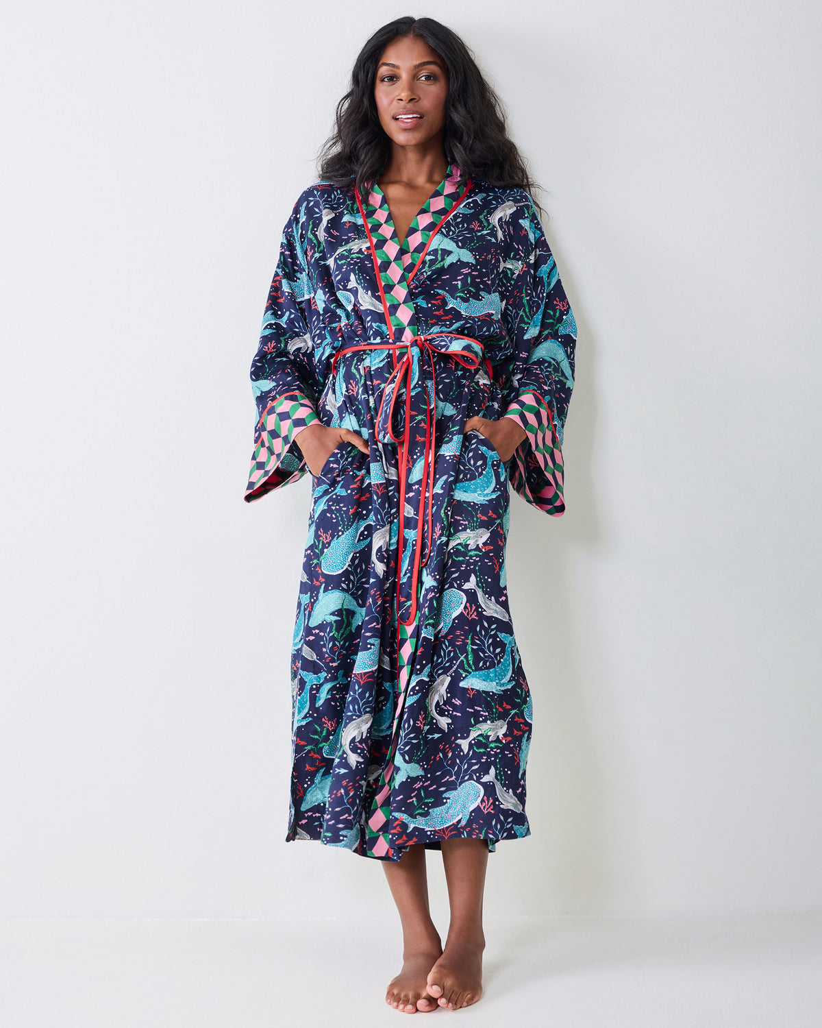 Full front view of a model wearing the navy Arctic Sea Life Eco Satin Robe, showing the whale print, contrasting trim, tie belt, wide cuffs, and pockets.