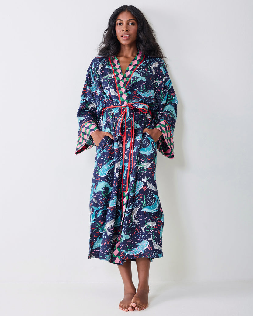 Full front view of a model wearing the navy Arctic Sea Life Eco Satin Robe, showing the whale print, contrasting trim, tie belt, wide cuffs, and pockets.