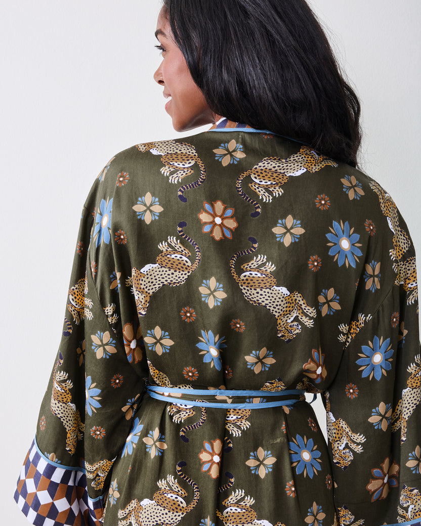 Back view of the olive robe showing the leopard-and-floral print, blue waist ties, and contrasting geometric sleeve cuffs.