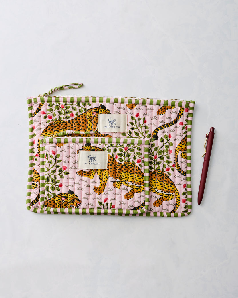 Two pink leopard-print zippered pouches displayed together beside a pen.