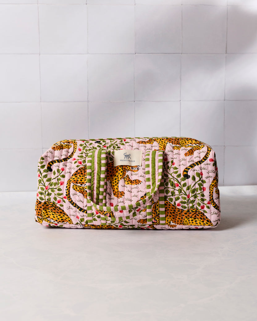 Closed pink leopard-print quilted hair tool travel case with green striped handles