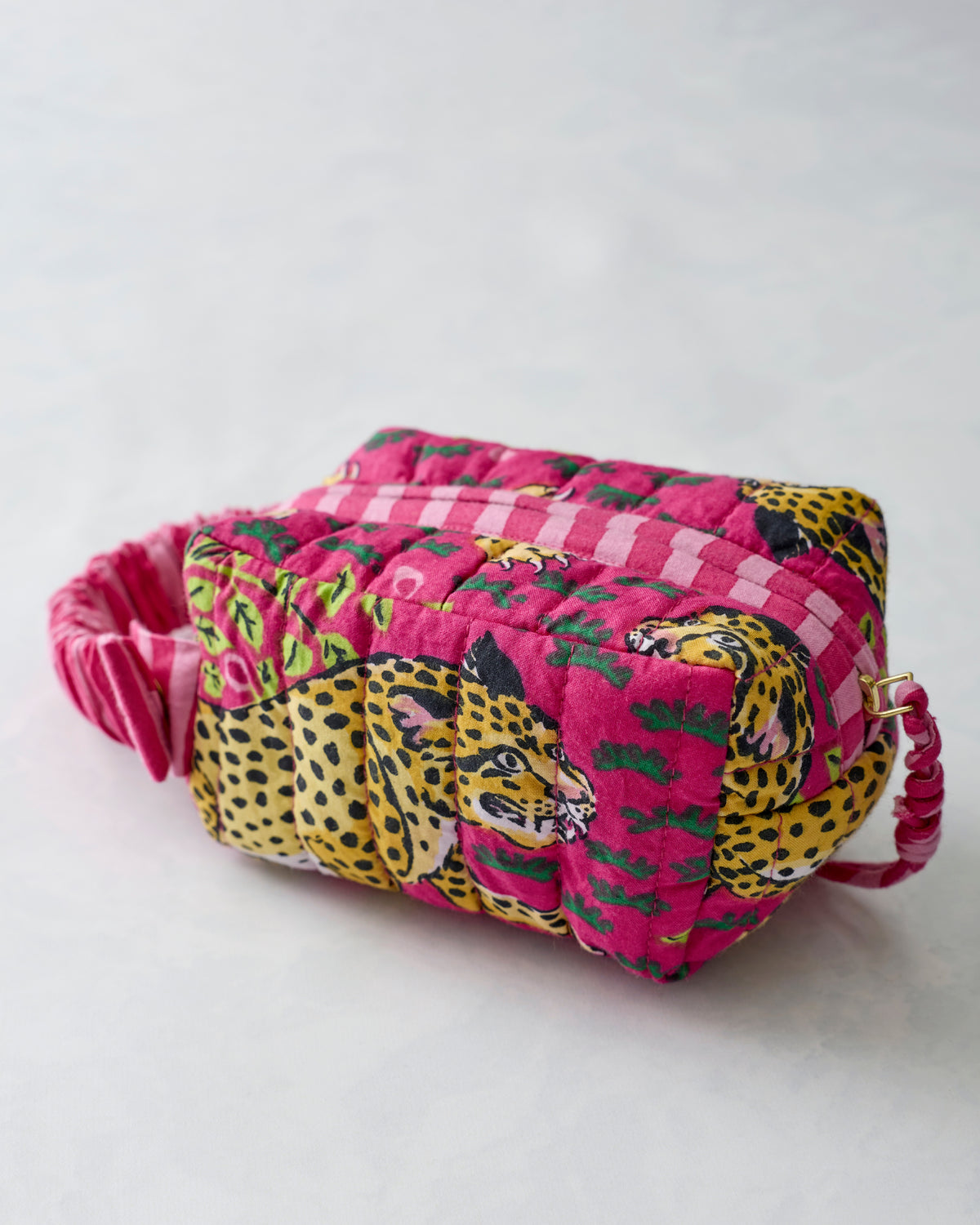 Close-up of the quilted Bagheera Hot Pink essentials wristlet with leopard print and pink-and-white striped sections.