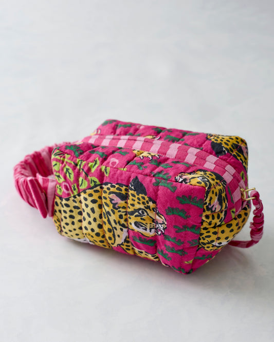 Close-up of the quilted Bagheera Hot Pink essentials wristlet with leopard print and pink-and-white striped sections.