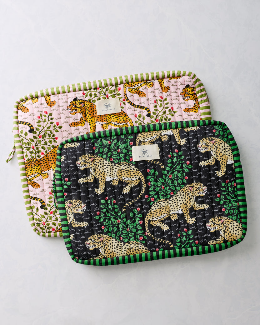 Black and pink quilted laptop sleeves with leopard and leafy floral prints displayed overlapping.
