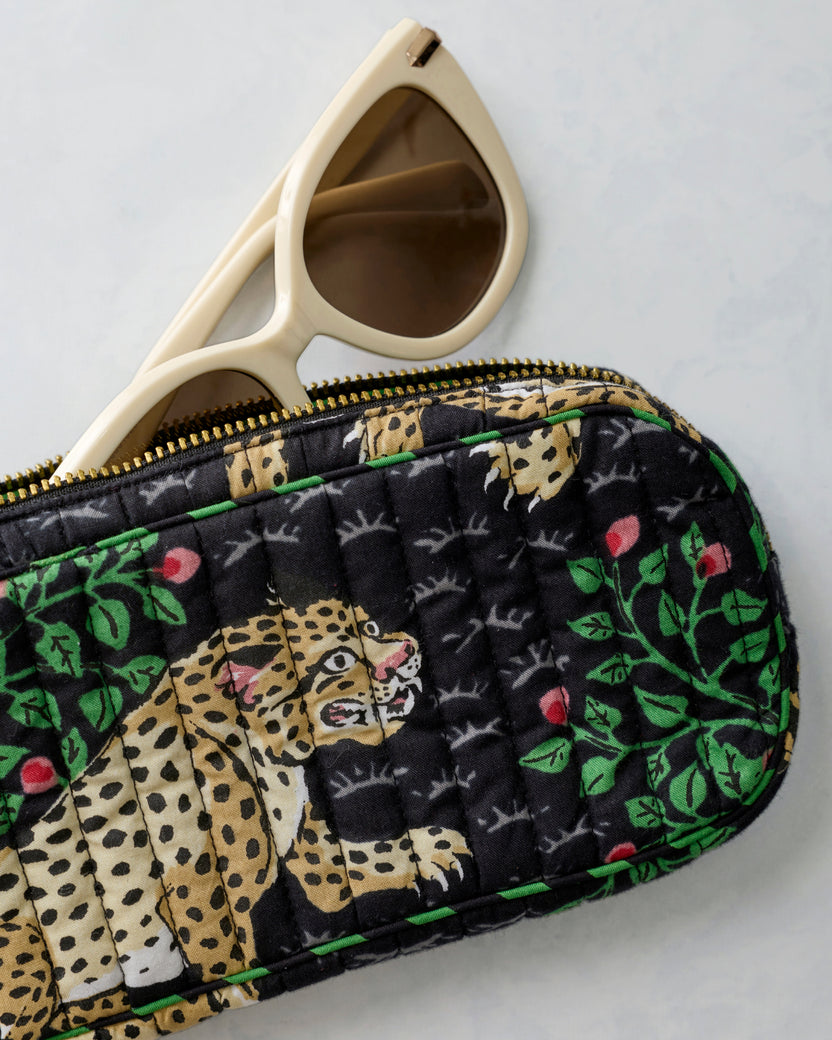 Close-up of the Bagheera Ink quilted sunglasses case with white sunglasses partly visible behind it.