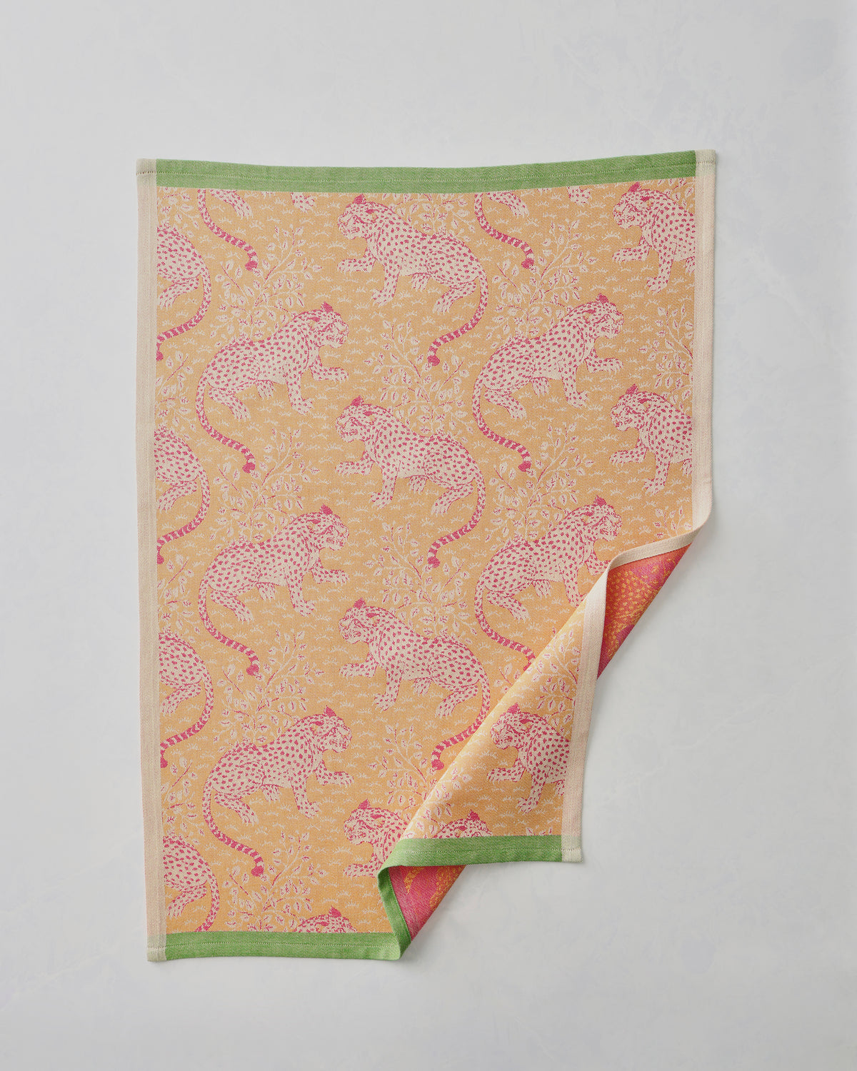 Yellow Bagheera jacquard tea towel with a repeating leopard-and-floral pattern, shown flat with one corner folded back.