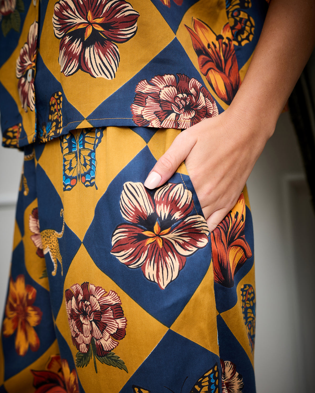 Close-up of the Golden Hour Wildest Dreams set showing its golden checkerboard print with flowers, butterflies, and leopards, plus a side pocket.