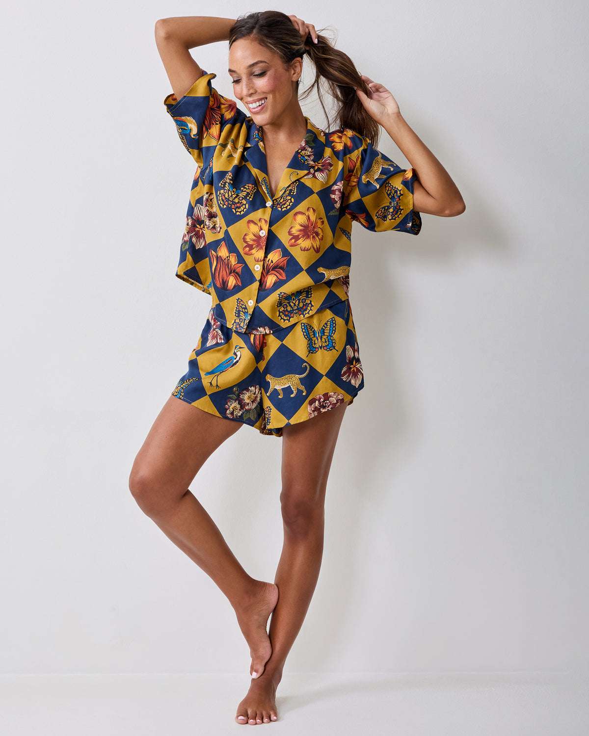 Full-length angled view of the Botanical Checkerboard pajama top and shorts on a model, showing the button-front top and matching patterned shorts.