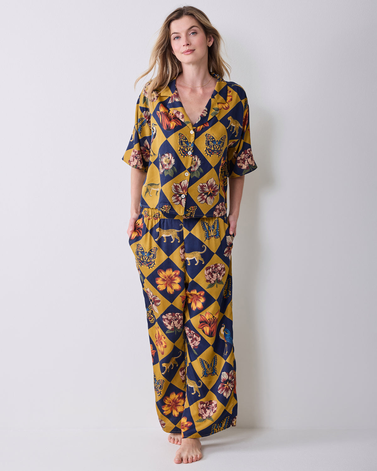 Front view of a person wearing the Golden Hour Botanical Checkerboard short-sleeved top and matching wide-leg pants, with hands in the pockets.