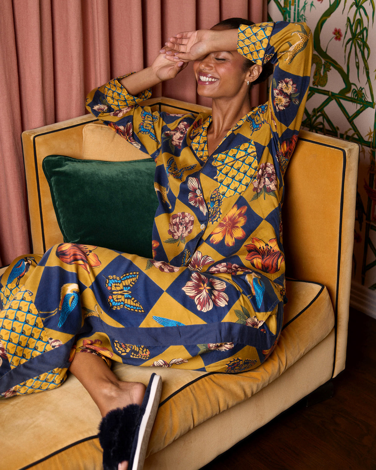 Seated view of a person wearing the Golden Hour Botanical Checkerboard long-sleeved collared top and matching wide-leg pants.