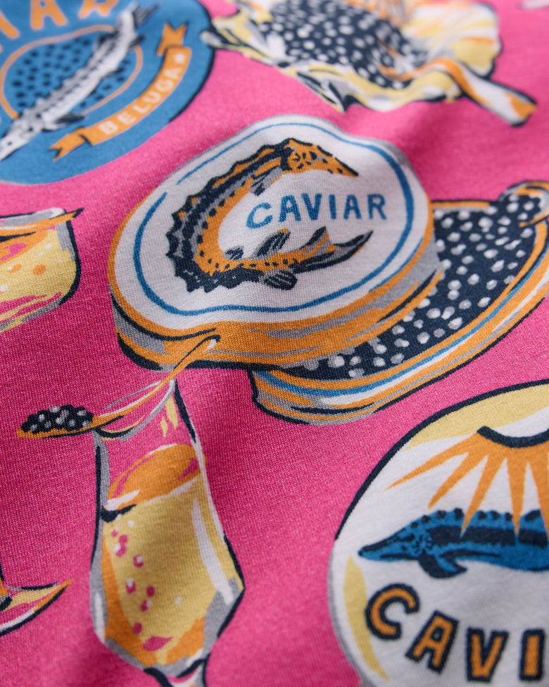 Close-up of the hot pink Champagne & Caviar pajama print with caviar tins and champagne glasses.