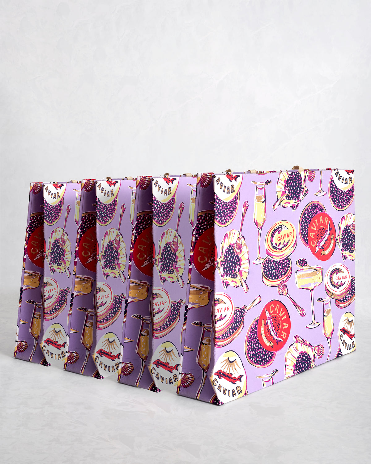 Set of four lavender paper gift bags with Champagne & Caviar print and sparkly handles.