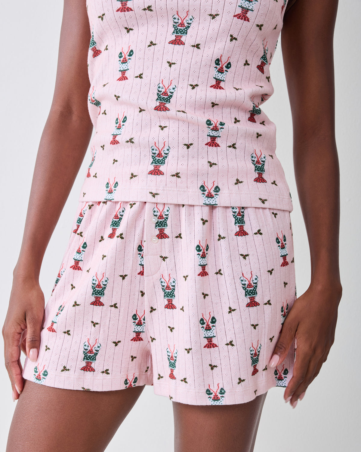Close-up of the Christmas Claws shorts showing the waistband, buttons, and repeating crustacean print.