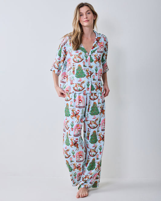 Front view of the short-sleeve button-down top and wide-leg pants in the Cowboy Christmas print.