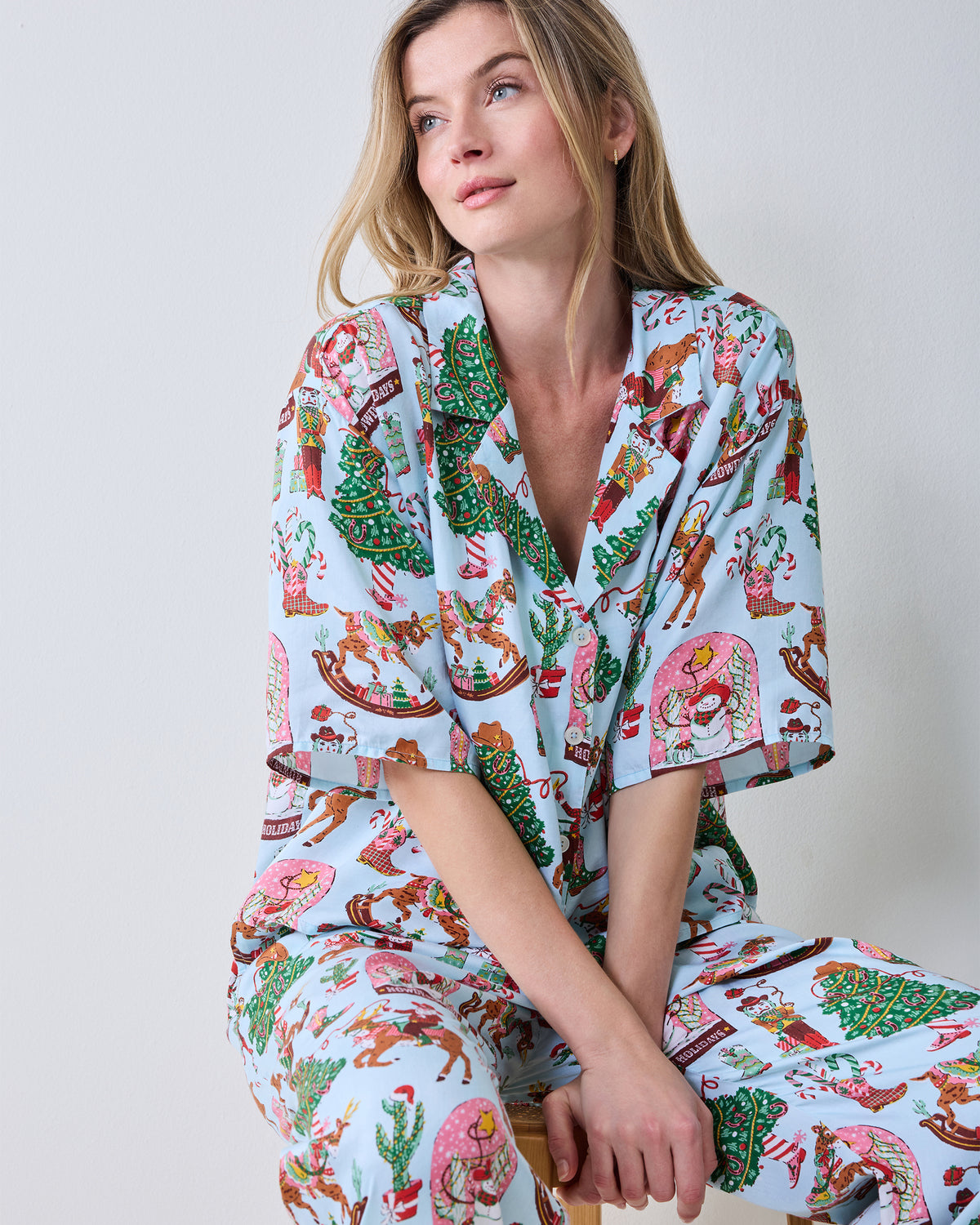 Close-up of the short-sleeve button-down top and printed wide-leg pants in the Cowboy Christmas set.