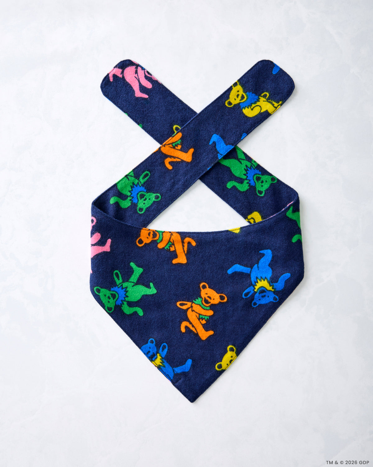 Single navy Dancing Bears pet bandana laid flat, showing crossed tie straps and colorful bear figures.