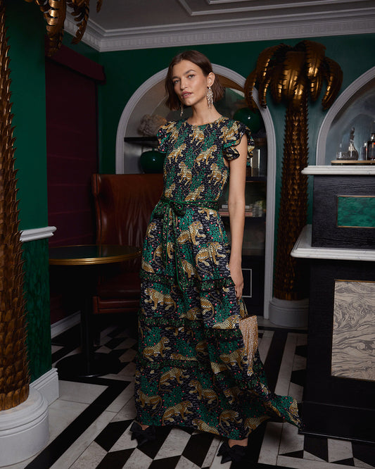 Front view of the Bagheera Ready To Ruffle Maxi dress in Ink, featuring a leopard and leafy-branch print, ruffled sleeves, waist tie, and tiered skirt.