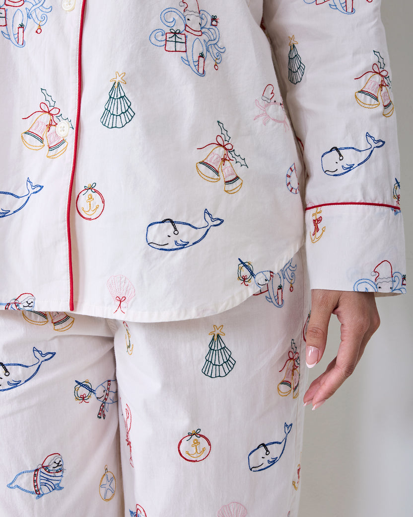 Close-up of the embroidered Yule Tides cloud Long PJ Set showing the button-front top, long sleeve cuff, and matching pants.