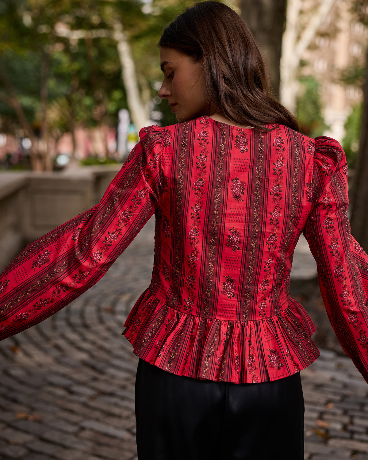 Back view of the Heirloom Red Festive Roses Lavelle blouse, showing its floral stripe pattern, fitted waist, and peplum hem.