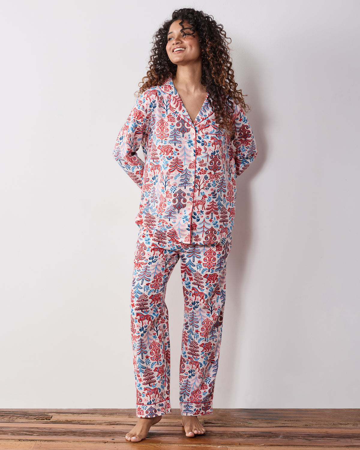 Three-quarter front view of the cream Folklore Forest long pajama set with matching button-front top and printed pants.