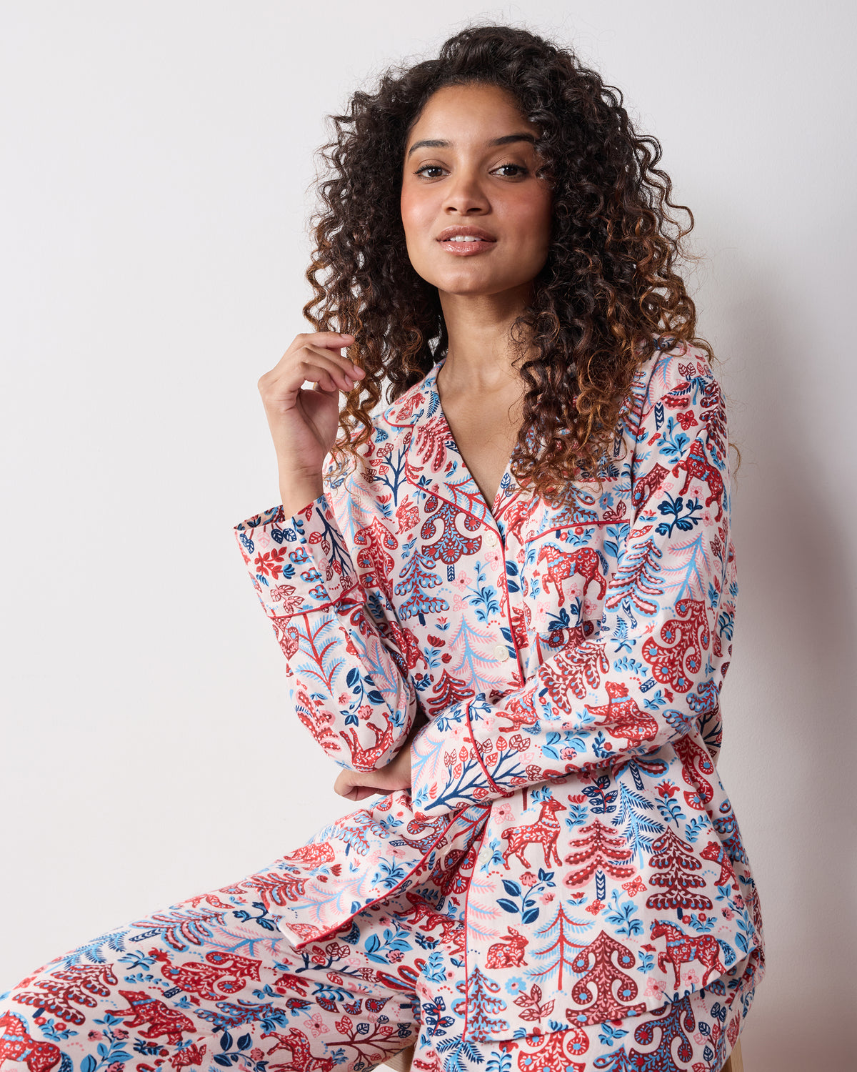 Person wearing the Folklore Forest long pajama set with a button-front top, long pants, and patterned print.