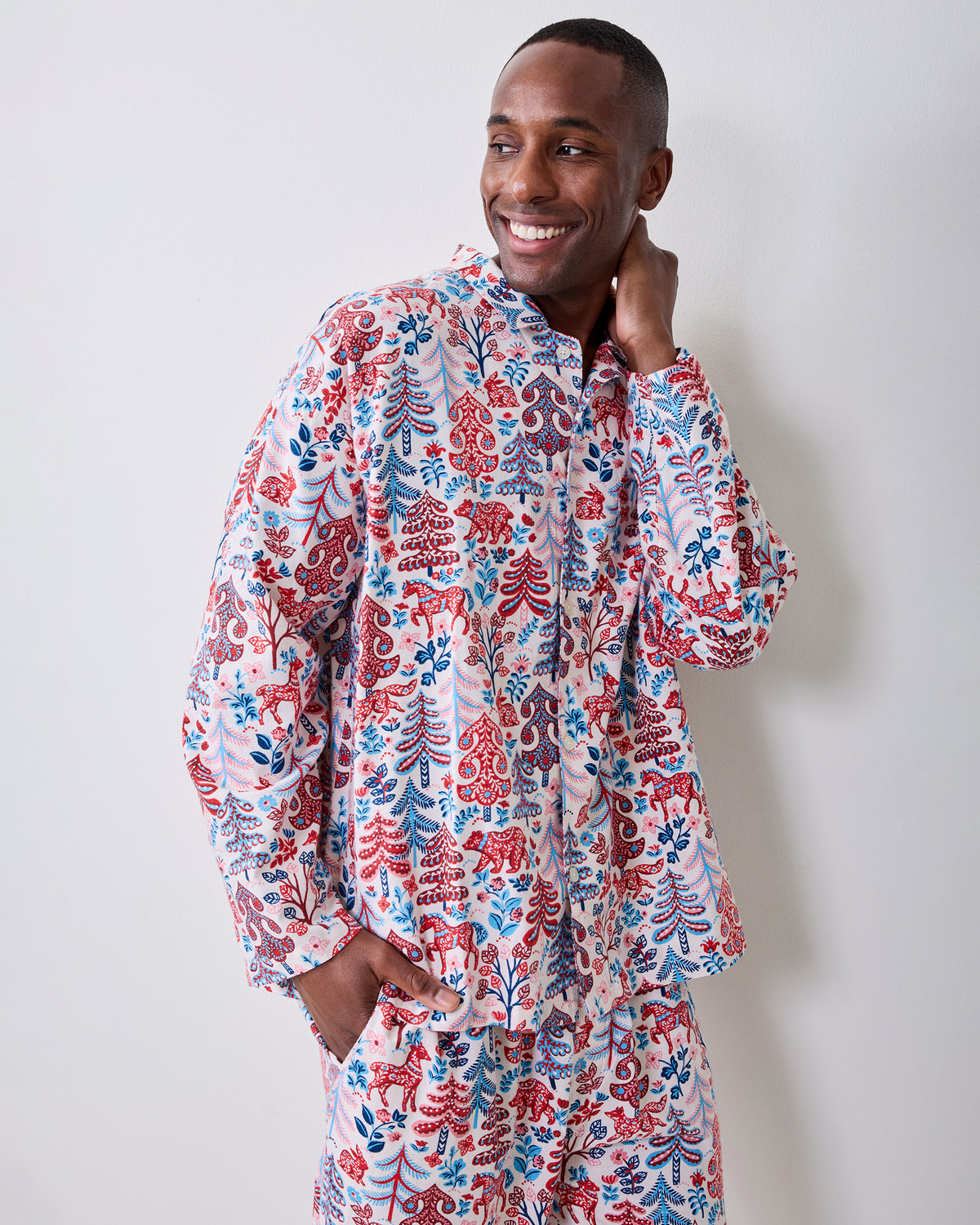 Person wearing a cream Folklore Forest printed long-sleeve pajama shirt and matching pants against a light background.