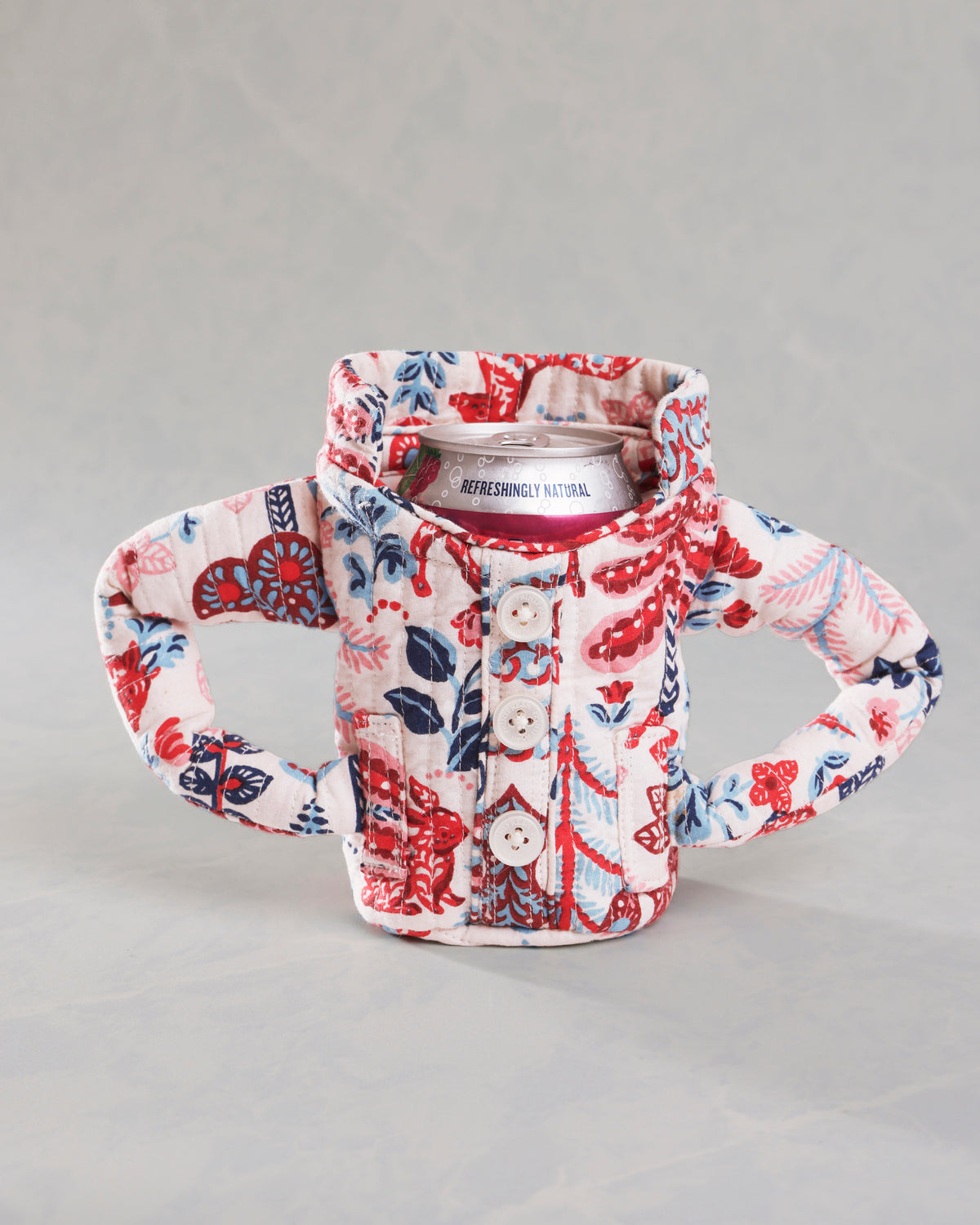 Front view of the cream pajama cozie around a beverage can, with button closure and side handles.