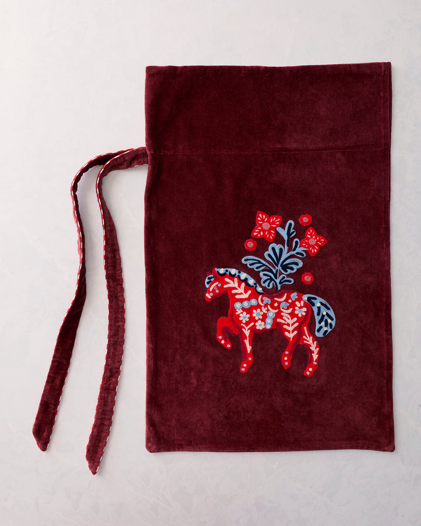 Flat view of a burgundy gift sack with a centered embroidered red horse and floral motif, with two ties extending to the left.
