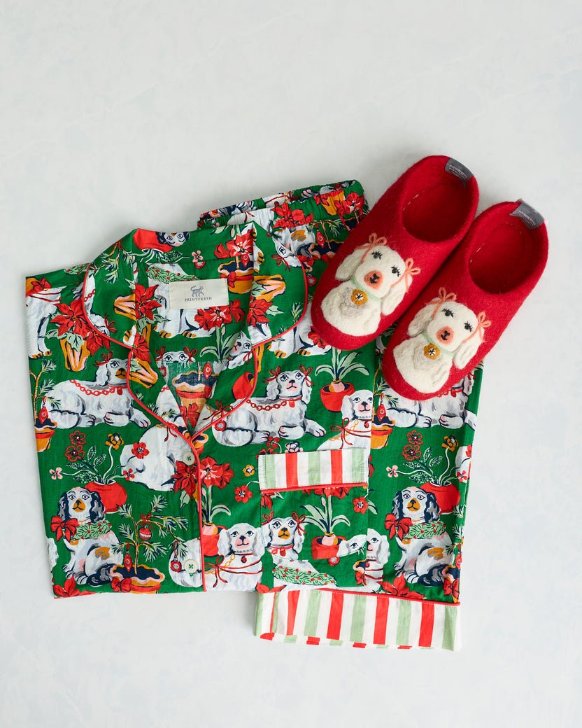Red Good Dog Christmas slippers displayed with a green dog-print pajama set.