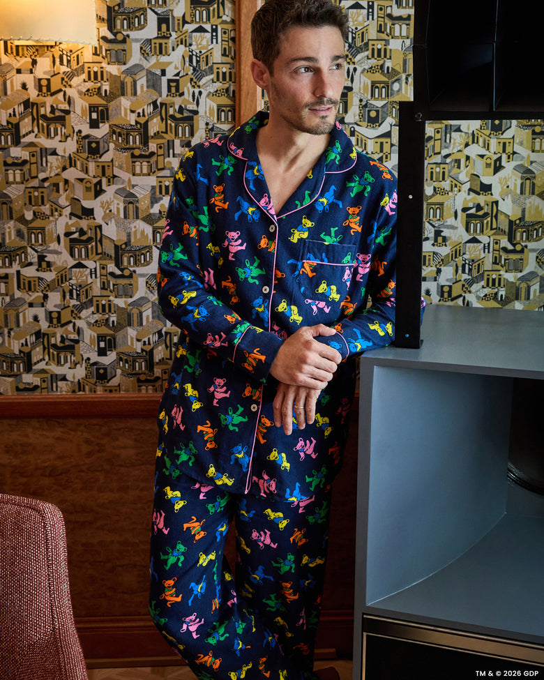 Front view of a person wearing the navy Dancing Bears long pajama set with colorful bear figures and contrast piping.