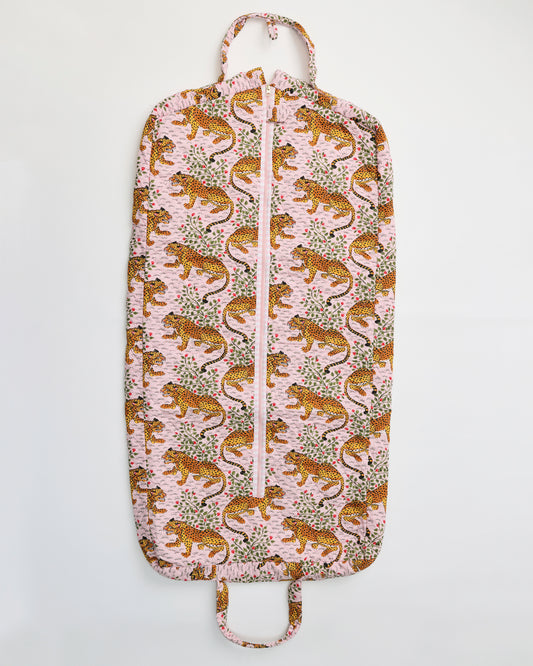 Flat view of the Bagheera blush garment bag with a front zipper, top hanger loop, bottom handle, and leopard-and-botanical print.
