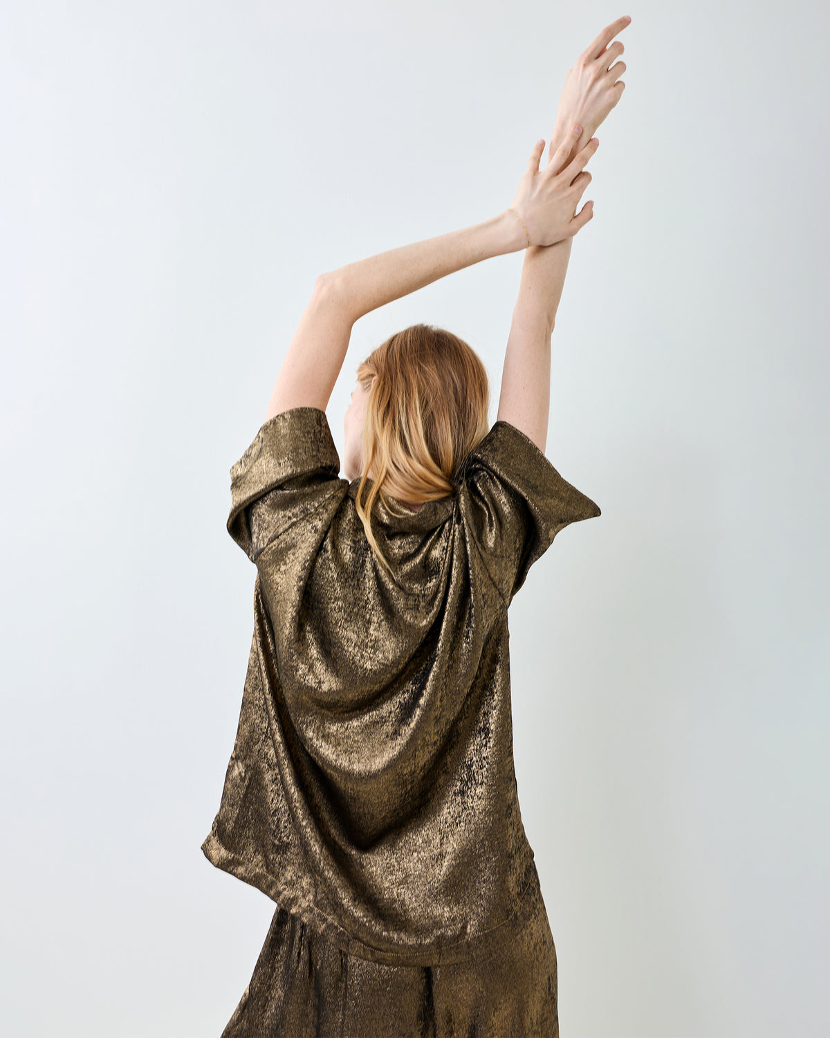 Back view of the gold Glitzy Lamé Blakely top and matching pants.