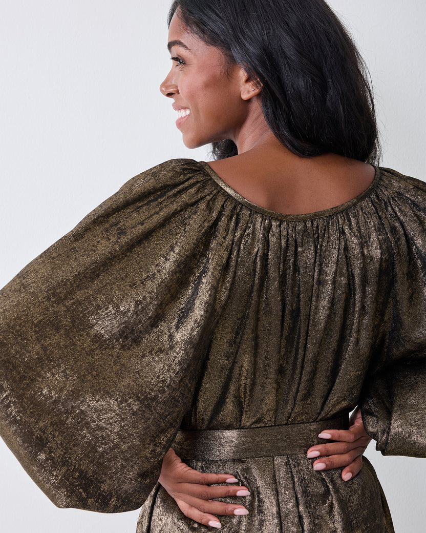 Back view of the gold Glitzy Lamé Felicity dress showing its gathered neckline and sleeves.