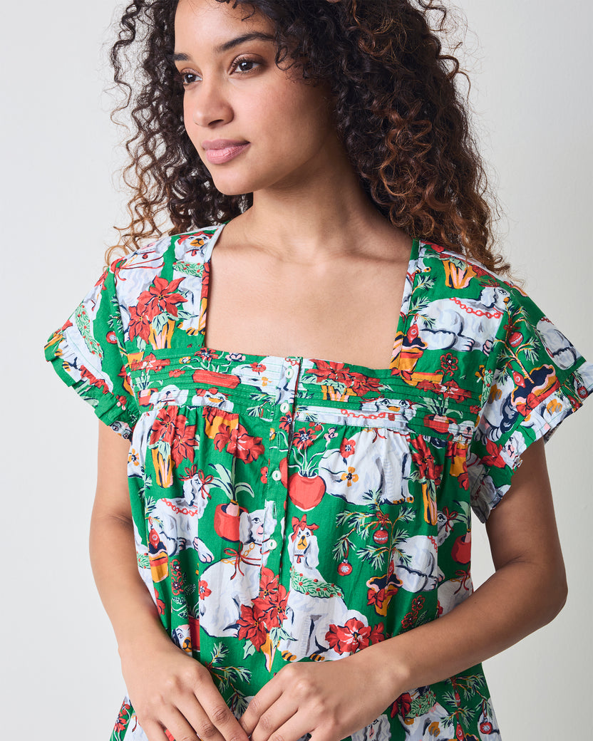 Close front detail of the green Good Dog Christmas nightgown showing the square neckline, ruffled sleeves, button placket, and printed fabric.