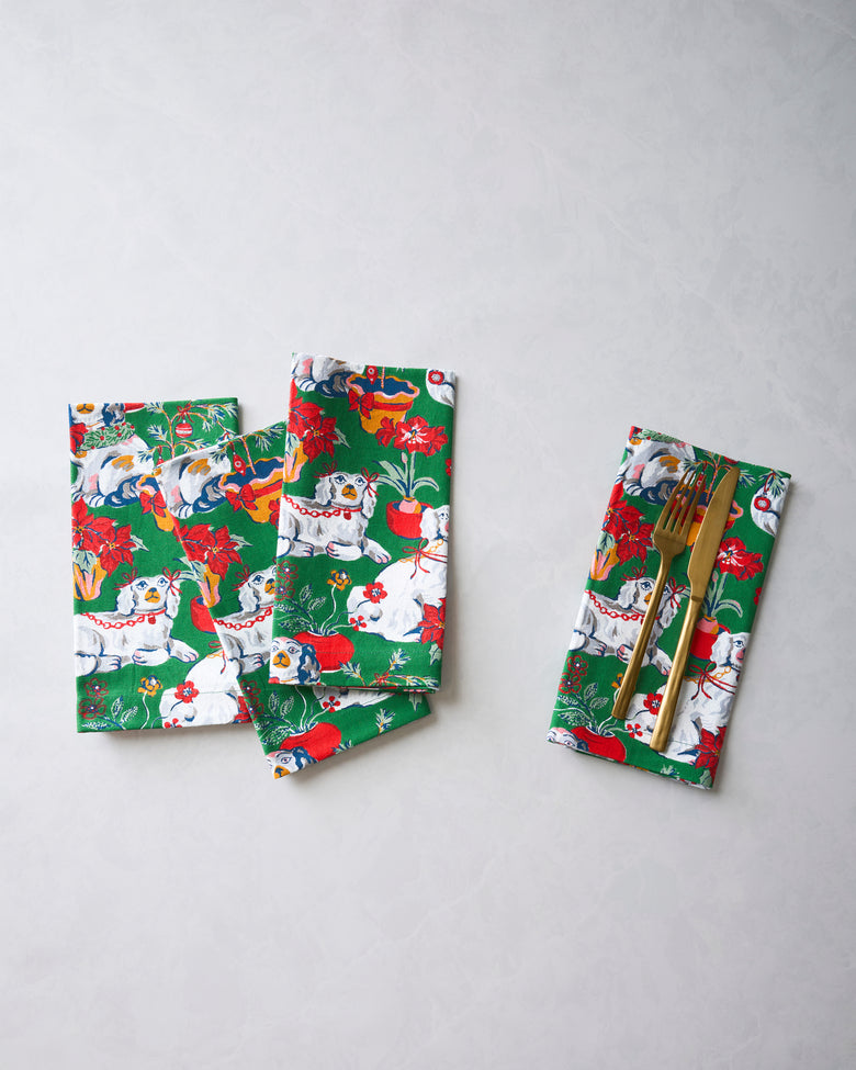 Good Dog Christmas dinner napkins arranged in a group, with one napkin holding a fork and knife