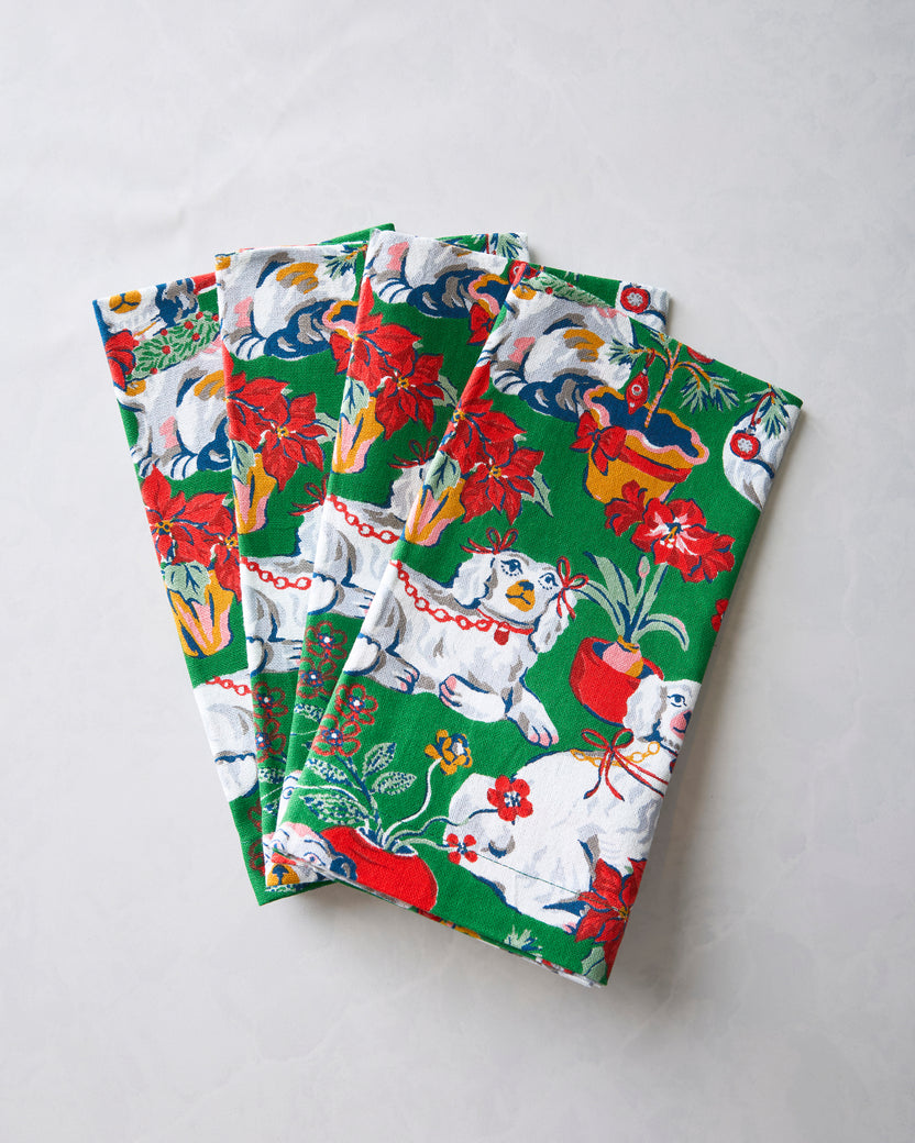 Four Good Dog Christmas dinner napkins layered together, showing the green dog-and-floral pattern