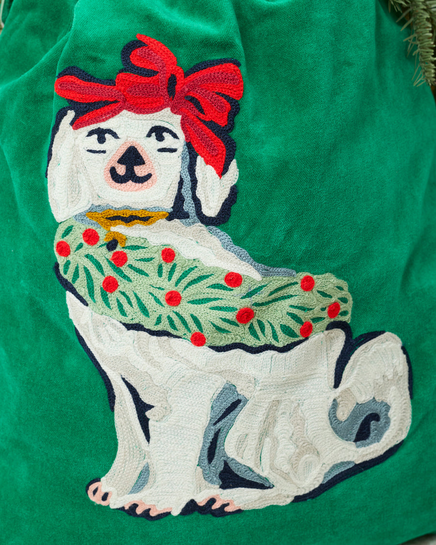 Close-up of the embroidered white dog and red bow design on the green Good Dog Christmas gift sack