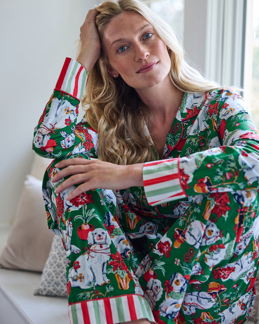 Close view of a person wearing the Good Dog Christmas evergreen tall long pajama set, showing the dog-and-holiday print and striped cuffs.