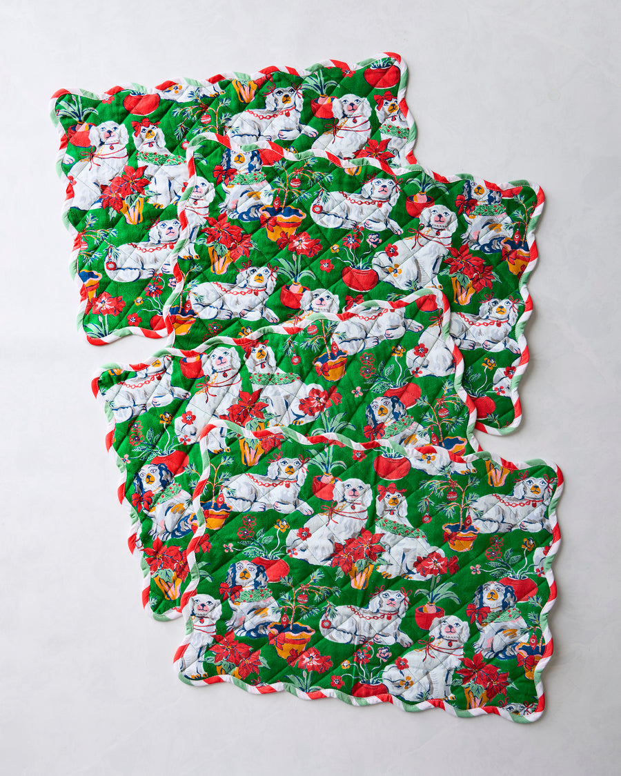 Four green Good Dog Christmas placemats arranged separately to show their scalloped edges and dog-and-holiday print.