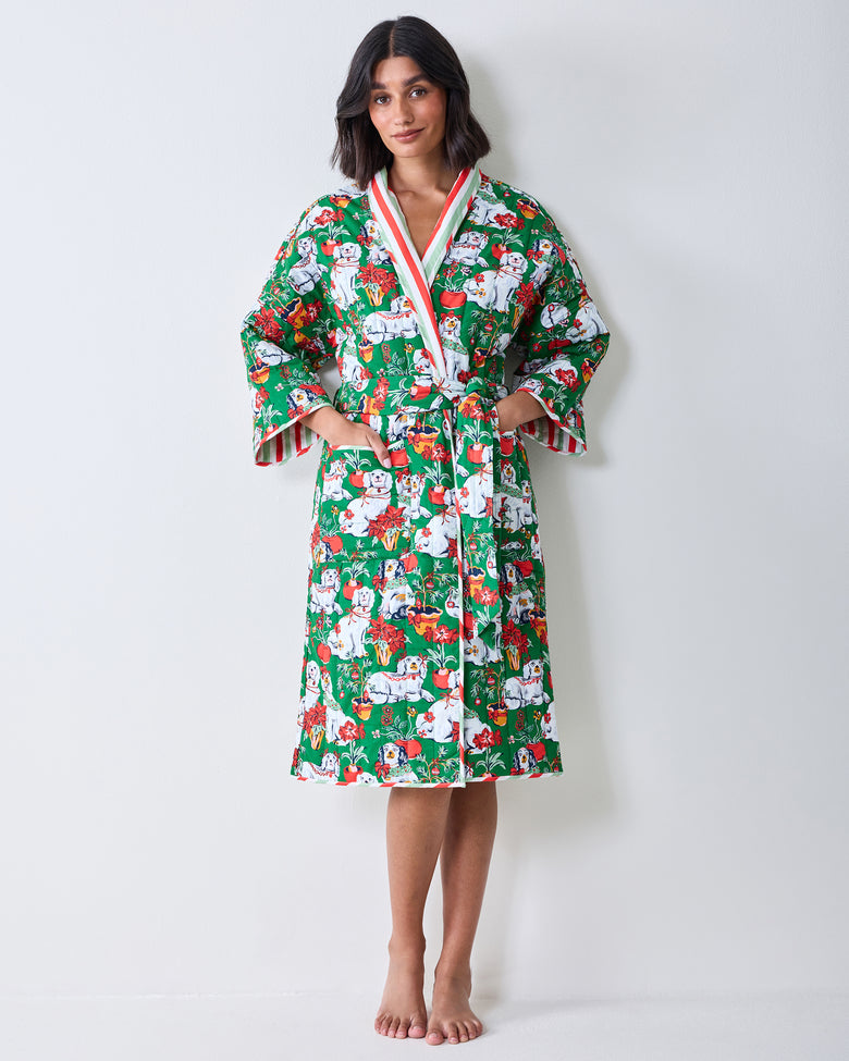 Full-length front view of a person wearing a green printed reversible quilted robe with a matching belt and pockets.