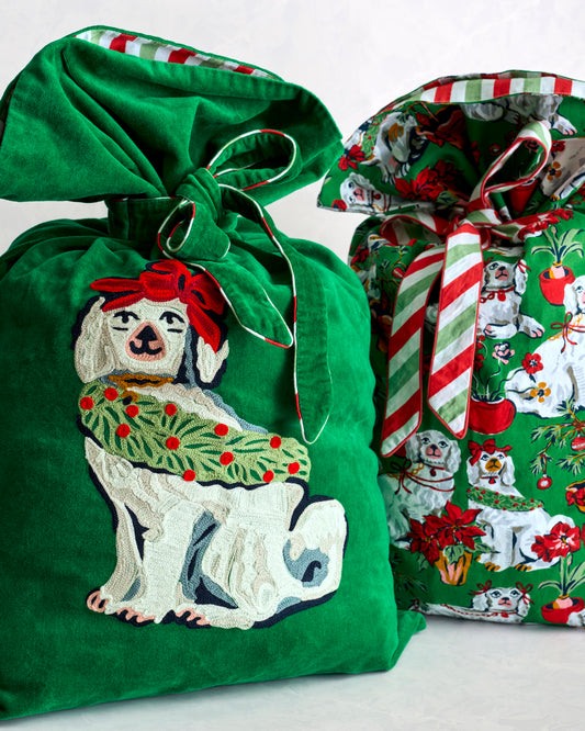 Two Christmas gift sacks: one green sack with a dog design and one coordinating sack with a festive dog print and striped ties.