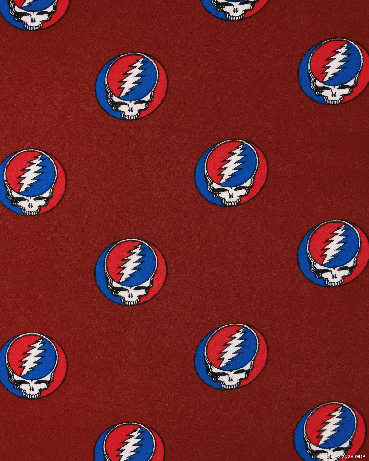 Close-up of red bandana fabric with a repeating circular skull-and-lightning-bolt print.