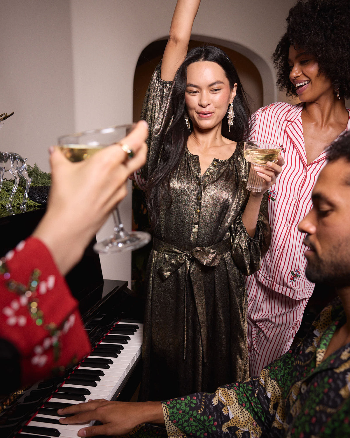 Person wearing the gold Glitzy Lamé Felicity dress with a waist tie at a gathering.