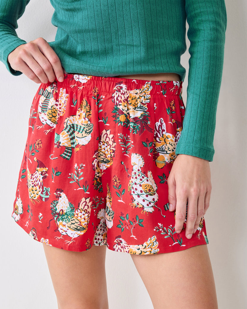 Close view of the red Holiday Hens boxer shorts showing the elastic waistband, short legs, and chicken-and-foliage print.