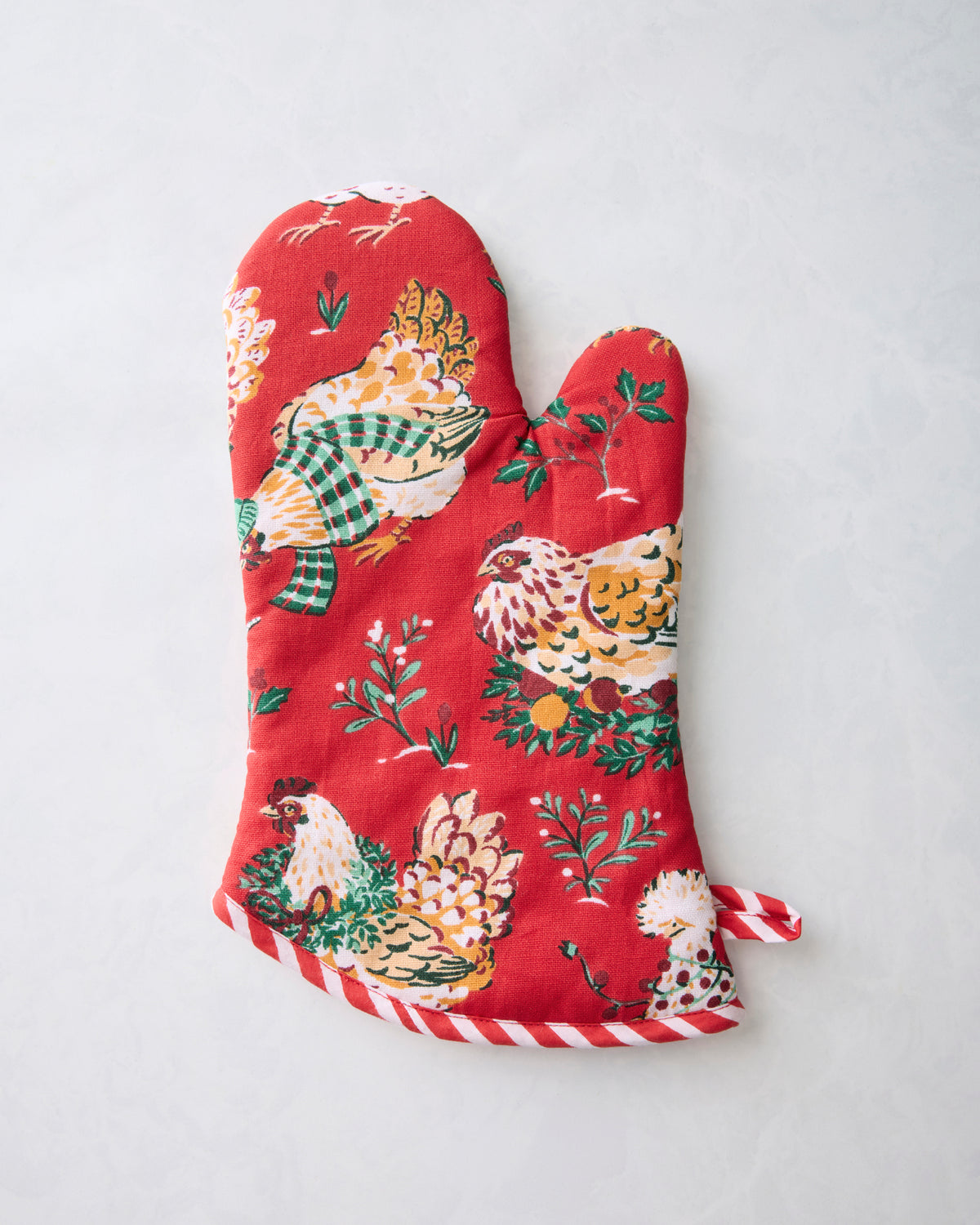 Front view of a red oven mitt with a chicken and greenery print and candy-cane striped trim.