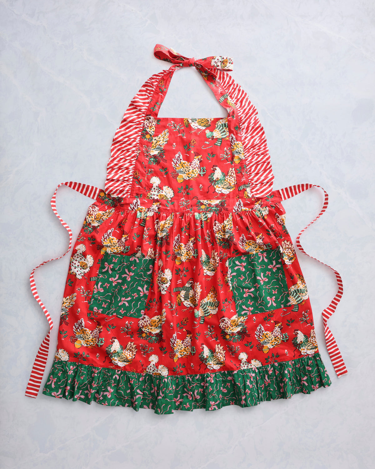 Red ruffle apron with chicken print, tie straps, and green patterned hem